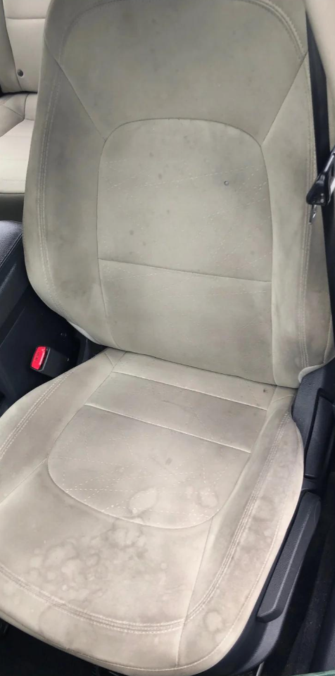 Siège de voiture en tissu clair couvert d'auréoles et de taches avant le shampouinage