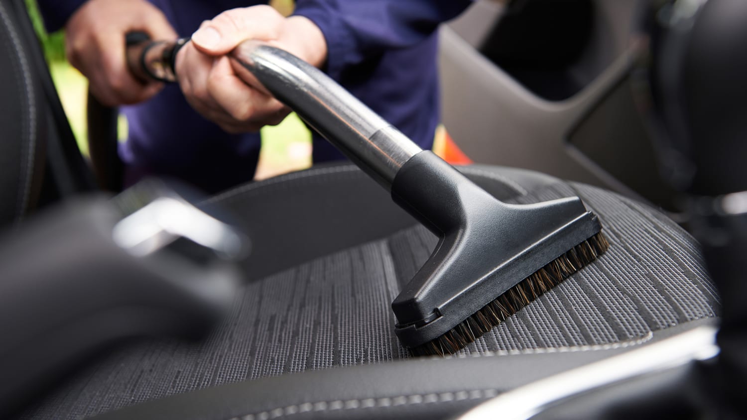 Aspiration d'un siège de voiture avec un aspirateur professionnel à brosse